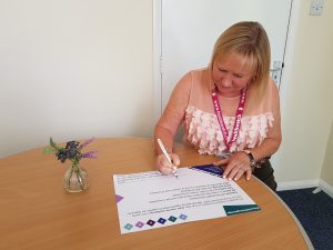 Kate Holt, CEO of Healthwatch Northamptonshire and Connected Together, signing the wellbeing pledge